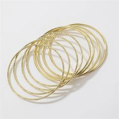 Provide an eye-catching look to your ensemble with this bangle set crafted in a versatile 18k gold-plated material. Includes eight 18k gold-plated bracelets 0.16" H x 2.76" diameter 18k gold-plated copper Gold-tone Brass Bangle As Gift, Elegant Gold-tone Metal Bangle, Gold-tone Brass Bangle, Modern Gold-toned Brass Bangle Bracelet, Gold-tone Tarnish Resistant Cuff Bangle, Gold Plated Bangles, Gold Plated Bracelets, Bangle Set, Apparel Accessories