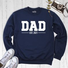 Custom Dad Sweatshirt, New Dad Sweatshirt, Custom Sweatshirt, Custom Dad Shirt, Dad Est Shirt, Father's Day Shirt, Dada Sweatshirt. Our products are Bella+Canvas branded. If Bella+Canvas is out of stock, I will send it from a trusted brand of the same size and quality. You can contact us in case of any problem or request. If you purchase a custom product, I will send you a message to confirm the design, don't forget to check your message box. Your satisfaction is important to us :) Please check the size chart before purchase products. We do not accept returns or exchanges on the products unless there is a mistake or damage caused by us. Please make sure that you get the right size for yourself by looking at the size chart before purchasing the products. We do not accept exchange and return White Long Sleeve T-shirt For Father's Day, Father's Day White Graphic Print Sweatshirt, White Graphic Print Sweatshirt For Father's Day, Casual Crew Neck Tops For Father's Day, Father's Day Long Sleeve Relaxed Fit Sweatshirt, Father's Day Casual Graphic Sweatshirt, Casual Graphic Print Sweatshirt For Father's Day, Father's Day Casual Sweatshirt With Name Print, Father's Day Cotton Sweatshirt With Name Print