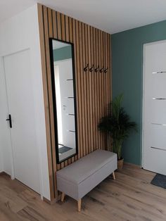 a room with a bench, mirror and plant on the wall next to door way