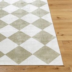 a white and gray rug on top of a wooden floor