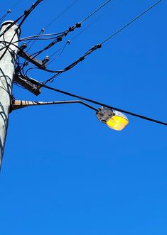 an electric pole and street light against a blue sky