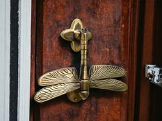 a close up of a door handle with a dragonfly on it