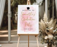 a welcome sign with flowers and greenery in front of an open door for graduation party