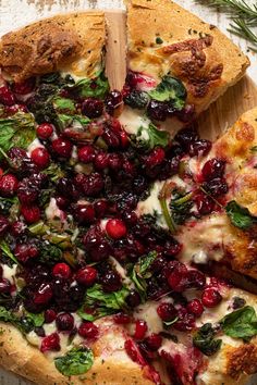 a pizza with cranberries and spinach on it