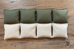 four green and white pillows sitting on top of a wooden floor next to each other