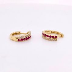 These gorgeous ruby and diamond earrings have 18 rubies and 30 diamonds. The diamonds make a border on either side of the rubies. The rubies are an amazing red color that is bright and commands attention. The earrings hug your earlobe and have a hinge so that it is securely fastened to your ear. The hinge will click in place and then you know that you are ready to do anything with your earrings on!Earrings: 1 SetMetal Quality: 14 Karat Yellow GoldEarring Type: Hoops/HuggiesHoop DIameter: 12.34 m Ruby And Diamond Earrings, Diamond Huggie Earrings, Ruby Earrings, Star Jewelry, Huggie Earrings, Ruby Diamond, Ruby Gemstone, Yellow Gold Earring, Custom Jewelry Design