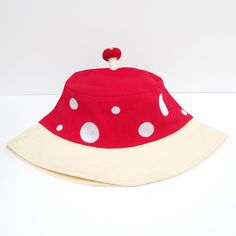 Woodland Cuteness! You'll be the cutest on the block, wearing this fun bucket hat designed by our talented artist mintandapple featuring a red and white mushroom design. This cutie is finished with a little felt mushroom friend on top! Perfect all year round and we guarantee smiles! About this hat: Cotton with embroidered details Spot Clean Original design by mintandapple Playful Cotton Bucket Hat With Short Brim, Playful Cotton Bucket Hat For Playtime, Playful Bucket Hat For Playtime, Playful White Bucket Sun Hat, Fun Red Adjustable Bucket Hat, Playful White Adjustable Bucket Hat, Playful Wide Brim Bucket Hat For Playtime, Fun Red Bucket Hat, Playful Adjustable White Bucket Hat