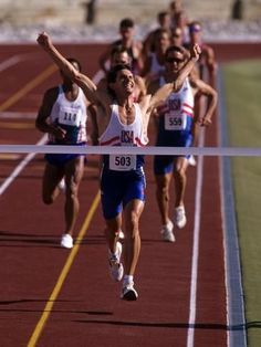 a group of men running across a track