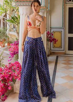 Featuring a handwoven nude pink silk bralette adorned with intricate silk yarn floral embellishments and crafted with kashida, beads, shells, mirrorwork for a touch of sparkle and whimsy. Completed with high-waisted vintage pleated blue silk trousers featuring shells on the waistband. An absolute choice for events like beach parties, holiday outings and destination weddings. Composition : Bralette - Handwoven Silk, Pants - Bandhani Silk Care: Dry Clean Only and Vacuum Storage This product can be customized for sleeves, length of blouse and neckline Delivery : 6-8 weeks as the product is hand crafted. Check Size Guide or choose MySize for free customisation (All Sizes above XL can be made at 15% additional cost) For more information and sizes please contact fabiliciousfashion@gmail.com or v Silk Bralette, Vacuum Storage, Pink Bralette, Silk Trousers, Indian Fashion Designers, Silk Jacket, Silk Yarn, Silk Pants, Nude Pink