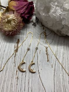 "Fine and delicate, these earrings flow from the earlobe in a beautiful gold line. Length can be adjusted depending how far the chain is pulled through the ear. These threader earrings measure 50 mm in length. Hanging from one end of the chain is an opal crescent moon, filled with cubic zirconia. Threader earrings come with wire ends to make it easy to thread the chain through any pierced hole of your ear, making these earrings fun to wear and play around with (from one pierced hole to another). Delicate 14k Gold Filled Threader Earrings, Dainty Moon Phase Earrings, Dainty Gold Plated Ear Climbers, Delicate Gold Threader Earrings With Ear Wire, Dainty Gold Plated Threader Earrings, Minimalist Gold Cartilage Earrings With Moon Charm, Gold Minimalist Cartilage Earrings With Moon Charm, Delicate 14k Gold Threader Earrings With Ear Wire, Elegant Gold Wire Wrapped Cartilage Earrings