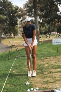 a woman is playing golf in the grass