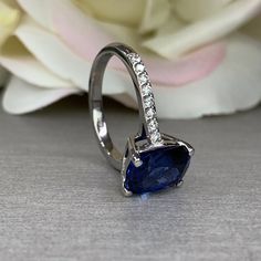 This ring is an elongated cushion cut lab created blue sapphire with round moissanite accents, 14k white gold #6316 We feature the finest quality lab grown sapphires in the world. The properties of lab-grown are physically, chemically and visually identical to natural, just grown in a lab setting. -Approximate total carat weight: 3.45ctw diamond equivalent -Center Stone Size: approx. 3.20ct diamond equivalent -Center Stone Shape: elongated cushion cut 10x8mm -Gem Type: lab created blue sapphire Elongated Cushion Cut Engagement Ring, Engagement Ring Blue Sapphire, Engagement Ring Blue, Ring Blue Sapphire, Elongated Cushion Cut, Blue Engagement Ring, Cushion Cut Engagement, Elongated Cushion, Ring Sapphire