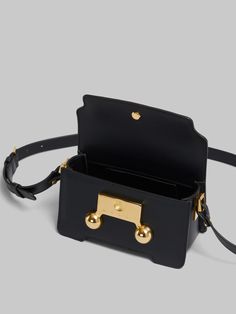 Trunkaroo rectangular mini shoulder bag crafted from calfskin leather. Front flap with magnetic closure, featuring engraved Marni lettering and oversized stud details. Contoured base on the front and back. One compartment with inside pocket. Lined in nappa leather. Detachable and adjustable buckled shoulder strap: can also be worn as a clutch. Designer Rectangular Satchel With Branded Hardware, Designer Rectangular Satchel With Gold-tone Hardware, Designer Flap Bag With Gold-tone Hardware, Designer Rectangular Flap Bag With Gold-tone Hardware, Designer Rectangular Box Bag With Adjustable Strap, Square Flap Bag With Branded Hardware For Travel, Designer Square Satchel With Branded Hardware, Designer Crossbody Box Bag With Branded Hardware, Designer Satchel With Detachable Strap And Rectangular Case