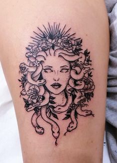 a woman's face with flowers and snakes on her thigh, done in black ink