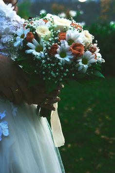 a woman holding a bouquet of flowers in her hands