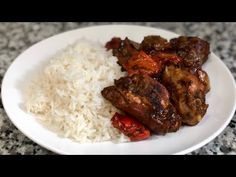 a white plate topped with meat and rice