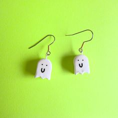 Clay ghost earrings with mixed metal hook. Each of these cute earrings is made of air dry clay, painted with acrylic paint, and sealed with resin. Earring hooks are surgical stainless steel, but if you have a metal allergy, plastic hooks are also available upon request. Just let me know in the personalization box. Each earring is handmade, so there may be slight variations from the photos. Perfect for any lover of spooky season, ghosts, and Halloween. Playful Halloween Earrings As A Gift, Playful Halloween Earrings For Gift, Playful Halloween Earrings For Gifts, Handmade White Earrings For Halloween, Fun White Halloween Earrings, Quirky Handmade Halloween Jewelry, Cute White Halloween Earrings, Hand Painted White Novelty Jewelry, White Hand Painted Novelty Jewelry