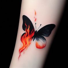 a tattoo with a butterfly on it and flames coming out of the wings that are black