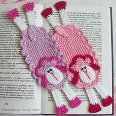 two pink and white monkeys sitting on top of an open book