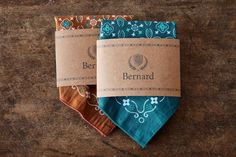 three different colored bandannas sitting on top of a wooden table