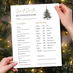 someone holding up a christmas question sheet in front of a tree with lights on it