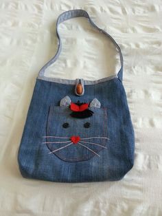 a denim bag with a cat face on it