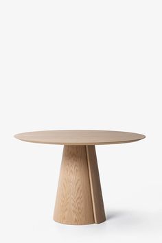 a round wooden table sitting on top of a white floor