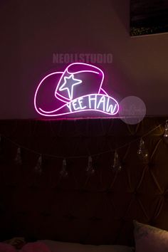 a neon sign that reads teenland on the side of a wall above a bed