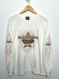 This tee shirt shows discoloration along the bottom side of both sleeves and on the upper right shoulder. Measurements Pit to pit: 20 inches Top to bottom: 27 1/2 inches Bleached Crew Neck Top For Streetwear, White Bleached Crew Neck T-shirt, Acid Wash Long Sleeve Streetwear Top, Distressed Long Sleeve Tops For Streetwear, Acid Wash Long Sleeve Tops For Streetwear, White Bleached Tops For Streetwear, White Bleached Top For Streetwear, Acid Wash Long Sleeve T-shirt With Letter Print, Acid Wash Long Sleeve T-shirt With Graphic Print