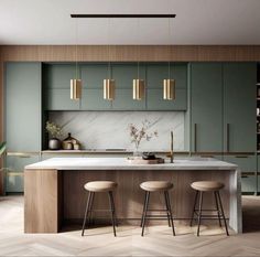 a modern kitchen with green cabinets and marble counter tops, stools at the island