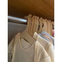 several baby clothes hanging on a rail in a closet