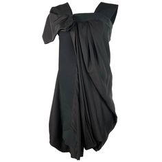 Product details: Black 100% silk asymmetrical style dress designed by Celine, featuring mini length and silver tone rear zip closure. Made in France. Silk Draped Mini Dress For Cocktail, Draped Silk Mini Dress For Evening, Modern Knee-length Asymmetrical Dress For Formal Occasions, Black Asymmetrical Silk Dress, Asymmetrical Mini Dress For Formal Occasions, Pre-draped Silk Mini Dress For Formal Occasions, Formal Pre-draped Silk Mini Dress, Silk Mini Evening Dress, Avant-garde Asymmetrical Hem Evening Dress