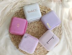 four different colored cases sitting on top of a wicker basket with flowers in the background