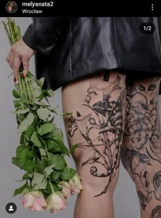 a person with tattoos holding flowers in their hand and wearing black leather jacket on the other side