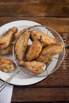 fried chicken wings on a plate with tongs