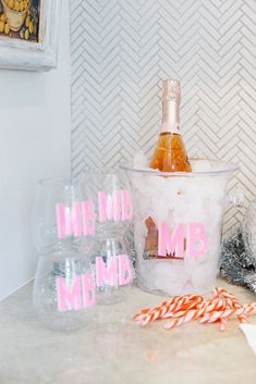 a bottle of champagne and candy canes on a counter with the words mr and mrs in pink letters