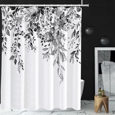 a shower curtain with black and white leaves on it