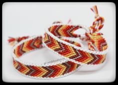 three woven bracelets with red, yellow and white designs on them sitting next to each other