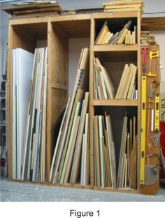 a bookcase filled with lots of books next to a red bin full of folders