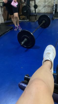 a person with their foot on a barbell