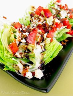 lettuce and tomato salad on a black plate