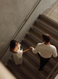 two people walking up some stairs holding hands