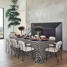 a dining room table is set with black and white checkered cloths, candles, and vases