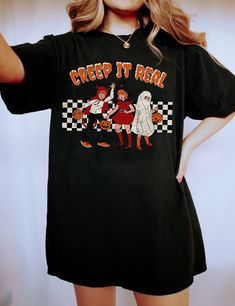 This cute vintage shirt is perfect for anyone who loves creepy, retro vintage halloween themes. Perfect for your favorite teacher, or as a gift for that special someone in your life. Retro Halloween, Creep it Real Shirt, Vintage Halloween Shirt, Witch Shirt, Retro Fall Shirt, Faded Fall Shirt, Teacher Halloween Shirt Overview -These t-shirts have-ribbed knit collars to bolster shaping. -The shoulders have taping for better fit over time. -Dual side seams hold the garment's shape for longer. -100 Vintage Black T-shirt For Fall, Black Retro T-shirt For Fall, Vintage Black Top With Funny Print, Retro Halloween T-shirt With Character Print, Black Vintage T-shirt For Fall, Retro Black Shirt For Fall, Vintage Halloween T-shirt With Letter Print, Vintage Crew Neck Halloween Tops, Vintage Crew Neck Tops For Halloween