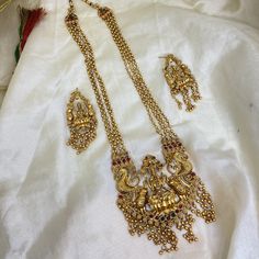 Long Haram Laxmi Temple Pendant Beaded Necklace Set for Women, Occasion Festive Jewelry, Indian Temple jewelry Necklace with Earrings, Gifts The Long Haram Antique Gold Plated Temple Laxmi Necklace Set with Earrings is an elegant and intricate piece of traditional Indian jewelry. The set includes a long necklace and a pair of matching earrings, all crafted from high-quality materials and designed with stunning detail. The necklace features a long, gold-plated chain that drapes elegantly over the Temple Jewelry Necklace, Long Haram, Gold Temple Jewellery, Traditional Indian Jewellery, Temple Jewelry, Unique Pendant Necklace, Indian Temple, Jewelry Indian, Temple Jewellery