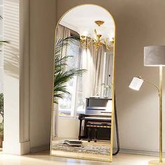 a mirror sitting on top of a wooden floor next to a lamp and a piano