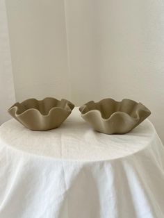 two bowls sitting on top of a white table