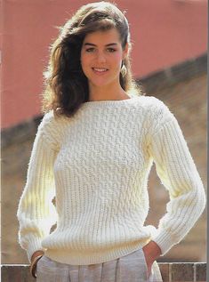 a woman wearing a white sweater and gray pants