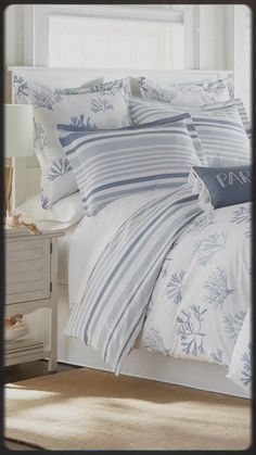 a bed with blue and white comforters in a bedroom