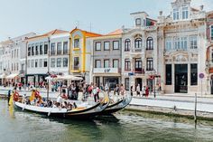 several boats are docked on the water in front of some buildings and people walking around